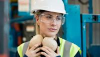 Woman wearing hardhat, safety glasses, and ear protection